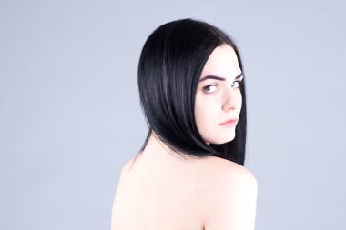 Stüdyoda gri bir arka plan üzerinde çıplak sırt kadınla