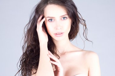 Büyük mavi gözleri ve kıvırcık saç baş dokunmadan güzel genç kadın. Kadının güzel yüz.