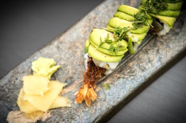 Suşi karides ile taş bir plaka üzerinde rulo.