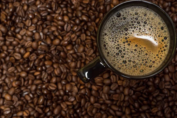 Kávébab háttér és fekete csésze forró itallal — Stock Fotó