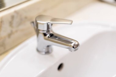 Klasik krom çeşmeli modern beyaz lavabo.