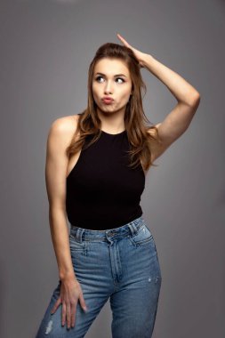 Gri arka planda sinirli genç bir kadın