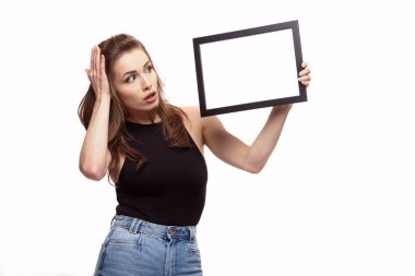 Beyaz arka planda mesajınız ya da resminiz için çerçeveli bir şey düşünen ya da merak eden genç bir kadın.