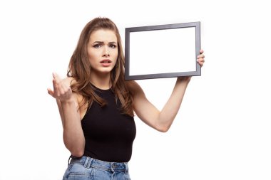 Genç kızgın ya da üzgün bir kadın beyaz arka planda mesajın ya da resmin için çerçeveli bir şey düşünüyor.