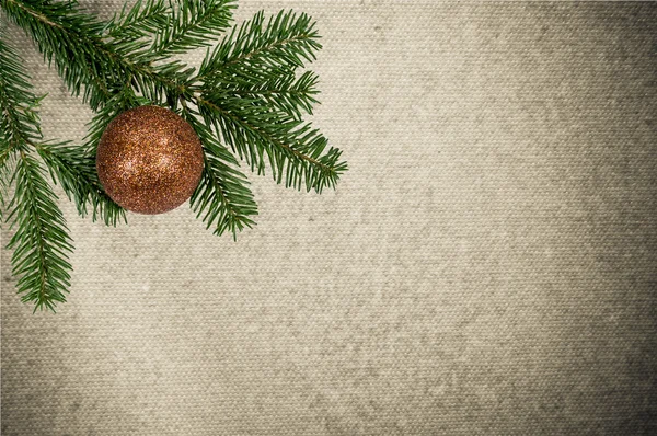 Branche verte avec boule de Noël sur fond de toile — Photo