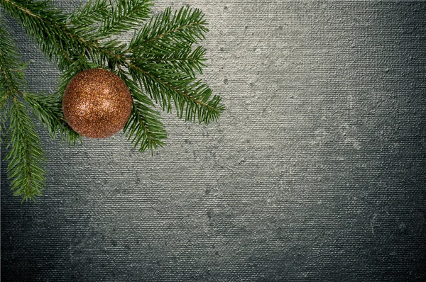 Grüner Zweig mit Weihnachtskugel auf Leinwand-Hintergrund — Stockfoto