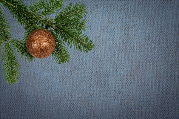 Grüner Zweig mit Weihnachtskugel auf Leinwand-Hintergrund — Stockfoto