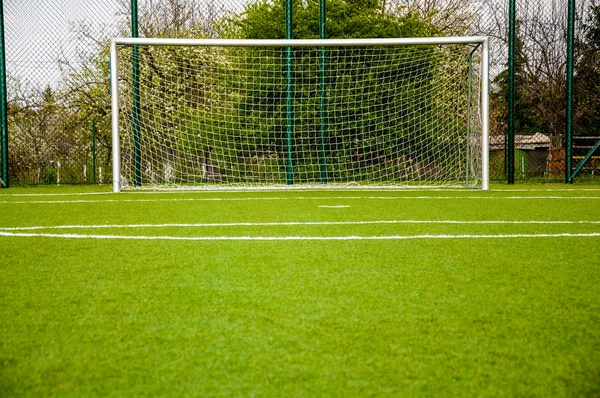 Portão de futebol no campo de esporte verde — Fotografia de Stock