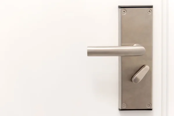 Door metal handle on the white door — Stock Photo, Image