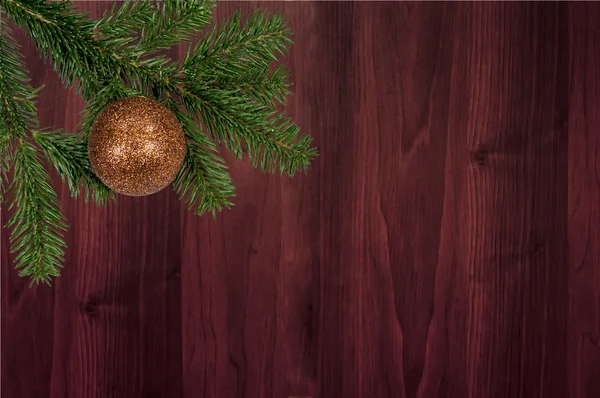 Grüner Zweig mit Weihnachtskugel auf Holzgrund — Stockfoto