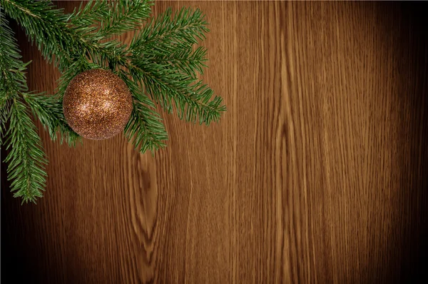 Ramo verde con palla di Natale su sfondo di legno — Foto Stock