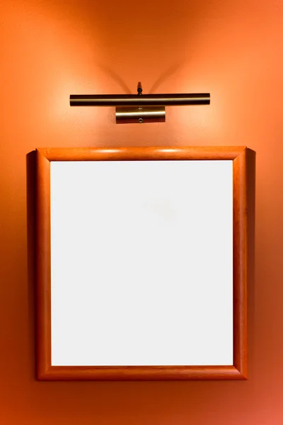 Picture frame illuminated by lamp on the wall — Stock Photo, Image