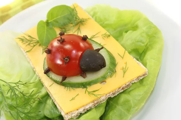 Crispbread with cheese, basil and ladybug — Stock Photo, Image