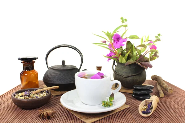 Китайская натуральная медицина с чашкой чая и цветами — стоковое фото