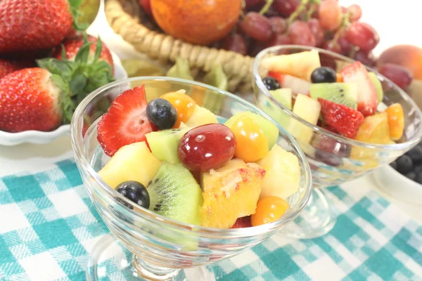 Salada de frutas em uma tigela em guardanapo xadrez — Fotografia de Stock