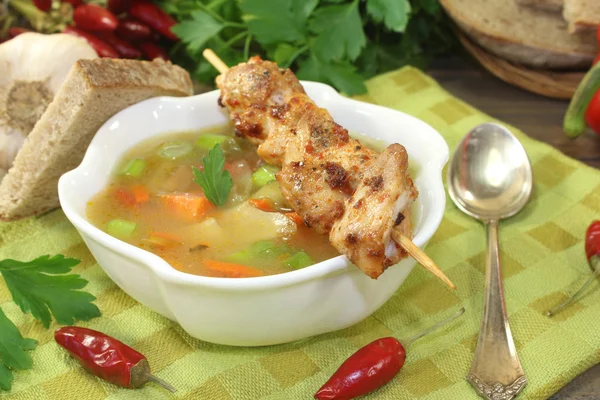 Poultry consomme with chicken skewers and parsley — Stock Photo, Image