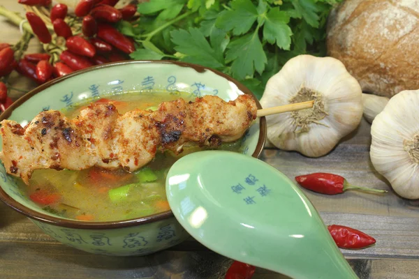 Poultry consomme with chicken skewers and smooth parsley — Stock Photo, Image