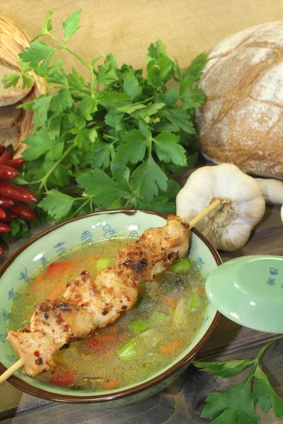 Poultry consomme with chicken skewer — Stock Photo, Image