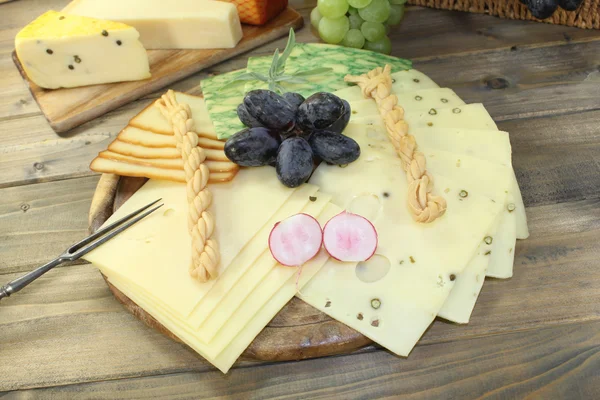 Slices of cheese with grapes — Stock Photo, Image