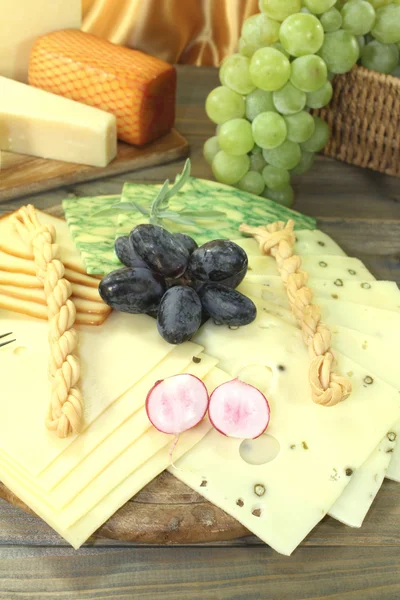 Rebanadas de queso con uvas y rábanos Imagen de archivo