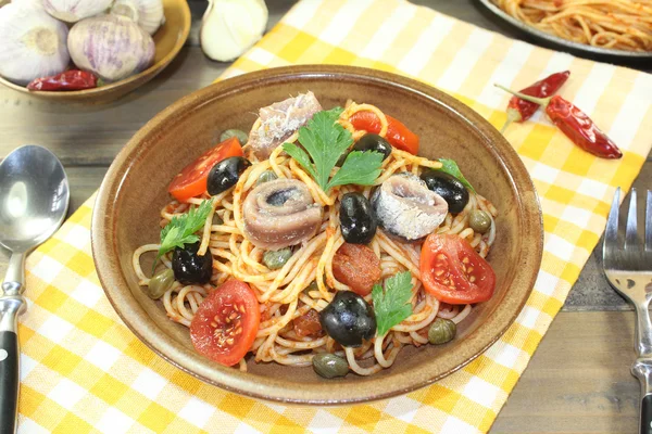 Spaghetti alla puttanesca s olivami, kapary a ančovičky — Stock fotografie