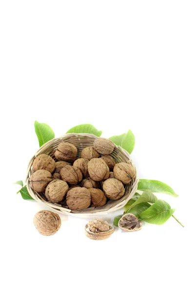 Walnuts with walnut leaves in a basket — Stock Photo, Image