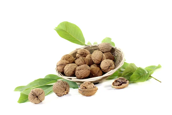 Crunchy walnuts with walnut leaves in a basket — Stock Photo, Image