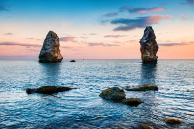 Büyük kayalara yukarıda deniz on Sunset
