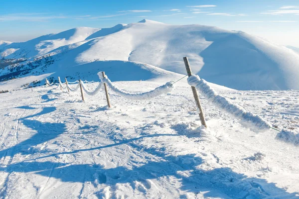 Recinzione con neve in inverno villaggio alpino — Foto Stock