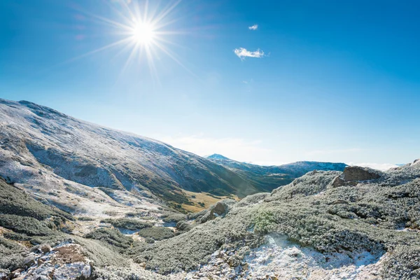 Montagne invernali e soleggiata valle verde — Foto Stock