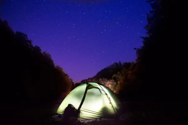 Tenda iluminada à noite na floresta — Fotografia de Stock