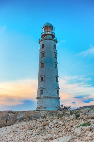 Geceleri deniz feneri. Gün batımında deniz manzarası — Stok fotoğraf