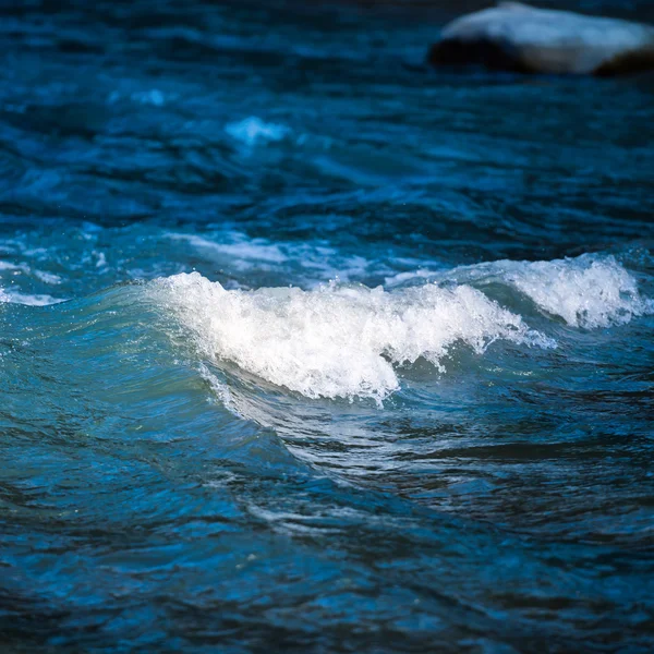 Sea wave på mörk blå vatten — Stockfoto