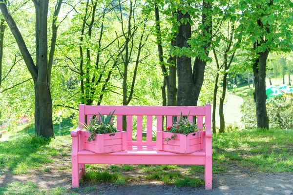 Banco rosa en parque verde — Foto de Stock