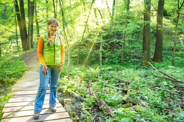 Vrouw op brug in het bos — Stockfoto