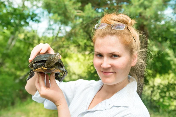 Blond woman holding a turtle — Stock Photo, Image