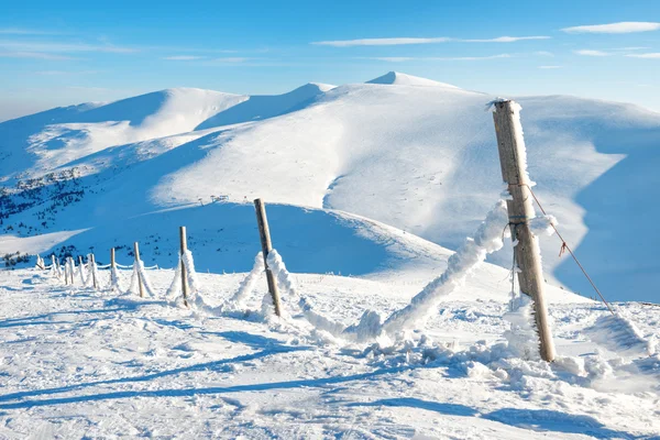 Zaun mit Schnee im winterlichen Alpendorf — Stockfoto