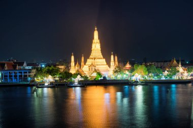 Gece, Şafak Tapınağı 'nı ya da Wat Arun' u ve güneş battıktan sonra Chao Phraya Nehri 'ndeki yansımasını aydınlattı. Bangkok, Tayland
