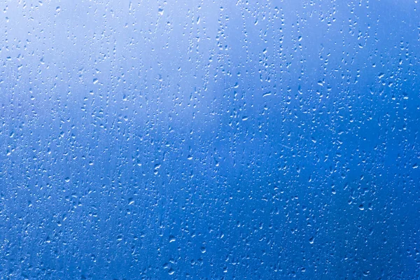 雨の水は青い窓ガラス表面にパターンをドロップ — ストック写真