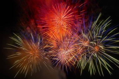 Kara gökyüzü arka planında kırmızı renkli havai fişekler. Tatil kutlaması.