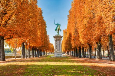Sonbahar parkı Paris 'te, portakal ağaçları ve kılıç taşıyan bir binicinin anıtı.