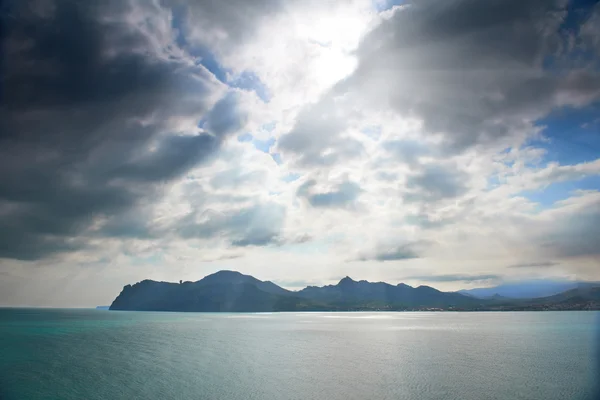 Dramatic clouds with island — Stock Photo, Image