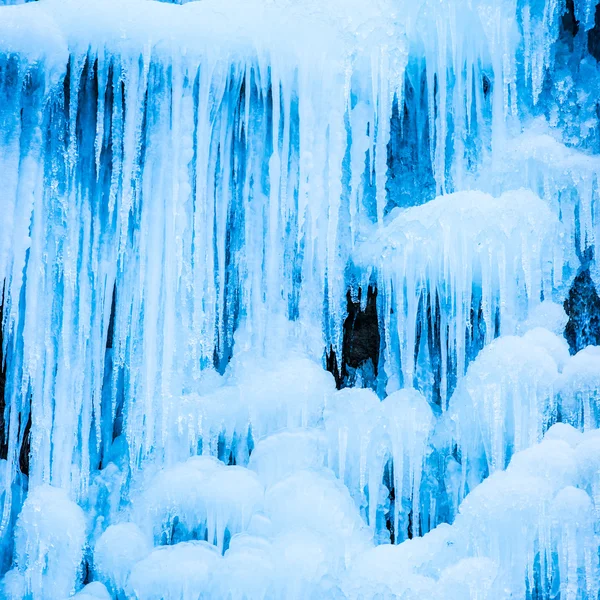 Gefrorener Wasserfall aus blauen Eiszapfen — Stockfoto