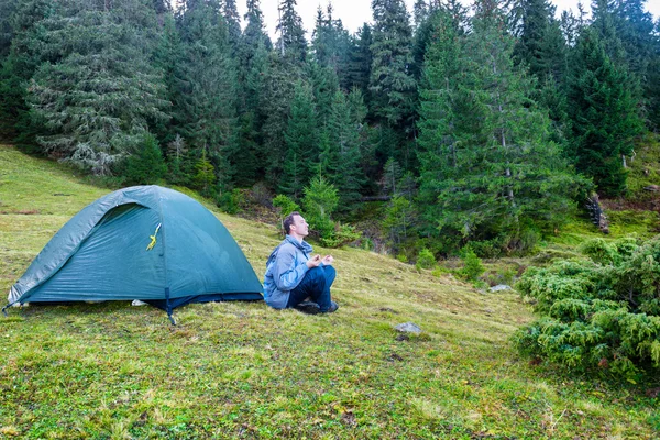 Man practicing yoga near blue camping tent — Stock Photo, Image