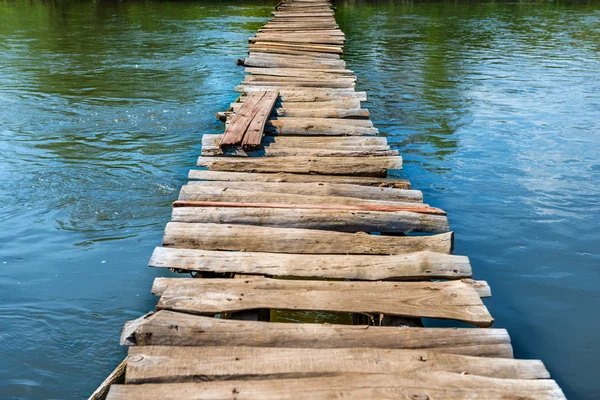 Ponte de madeira velha através do rio — Fotografia de Stock