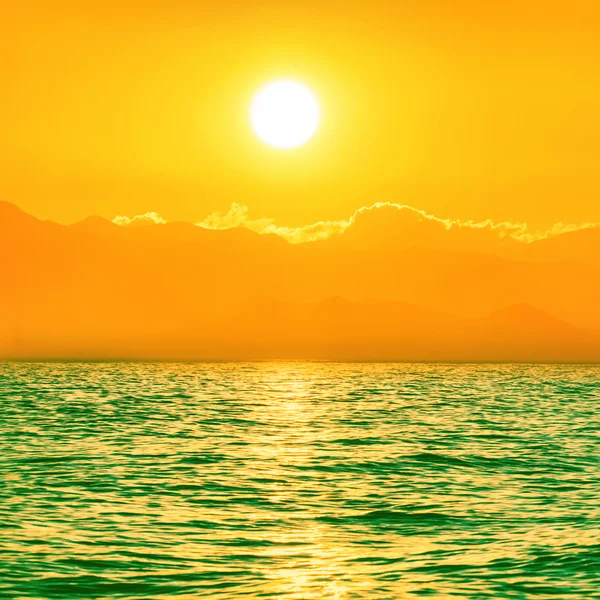 Zonsondergang boven de groene zee — Stockfoto
