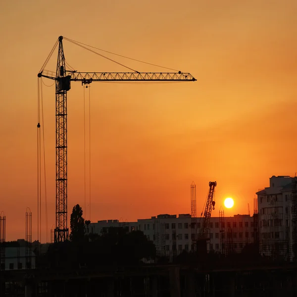 Industriekräne über dem Sonnenuntergang — Stockfoto