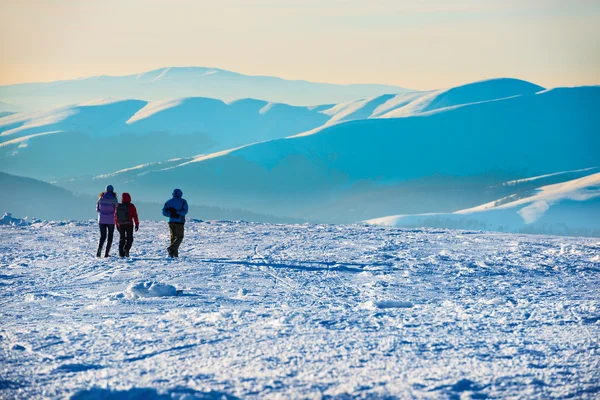 Menschen, die in winterlichen Bergen wandern — Stockfoto