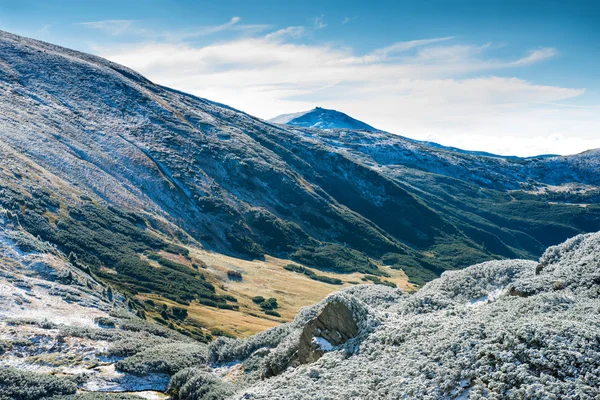 Munții de iarnă și valea verde însorită — Fotografie de stoc gratuită