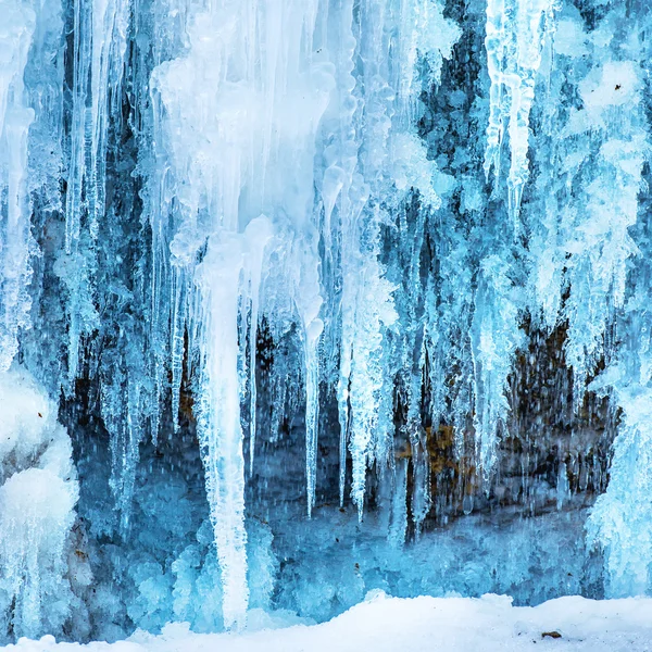 Gefrorener Wasserfall aus blauen Eiszapfen — Stockfoto